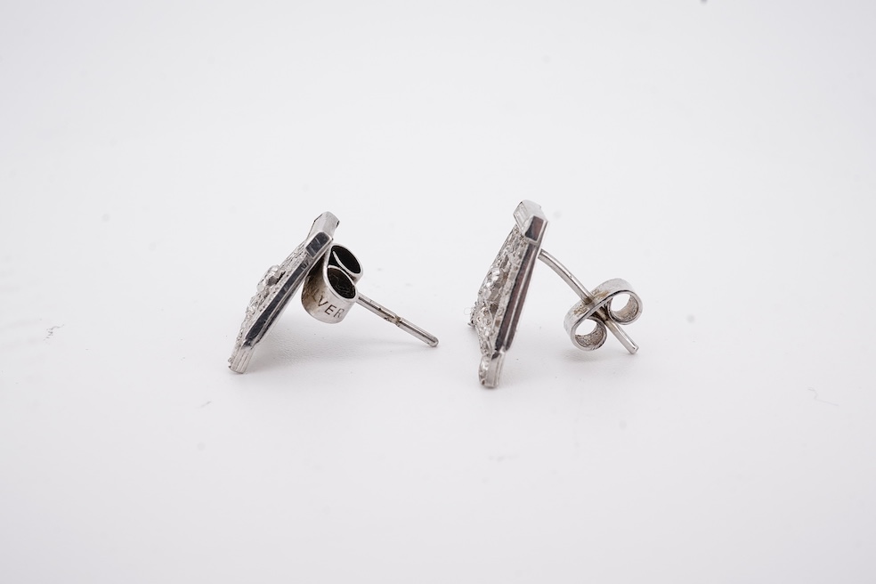 A pair of mid 20th century white metal and millegrain set diamond cluster set 'A' shaped ear studs(adapted from watch lugs?), set with round and baguette cut stones, 12mm, gross weight 3.2 grams.